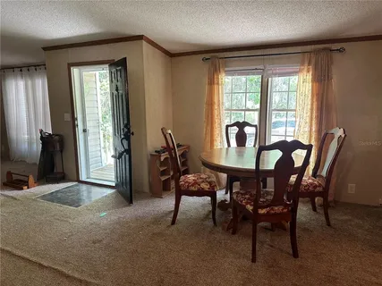 a view of a dining room with furniture and window