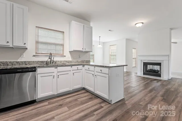 a kitchen with granite countertop white cabinets and white appliances