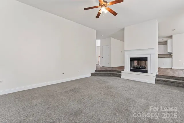 a view of a livingroom with a fireplace and ceiling fan