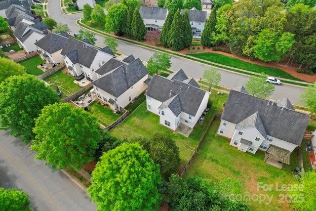 an aerial view of multiple houses with a yard