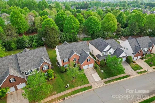 an aerial view of a house with garden space and street view