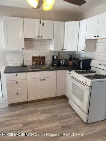a kitchen with granite countertop white cabinets and white appliances