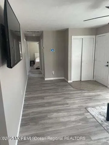 a view of a hallway with wooden floor and staircase