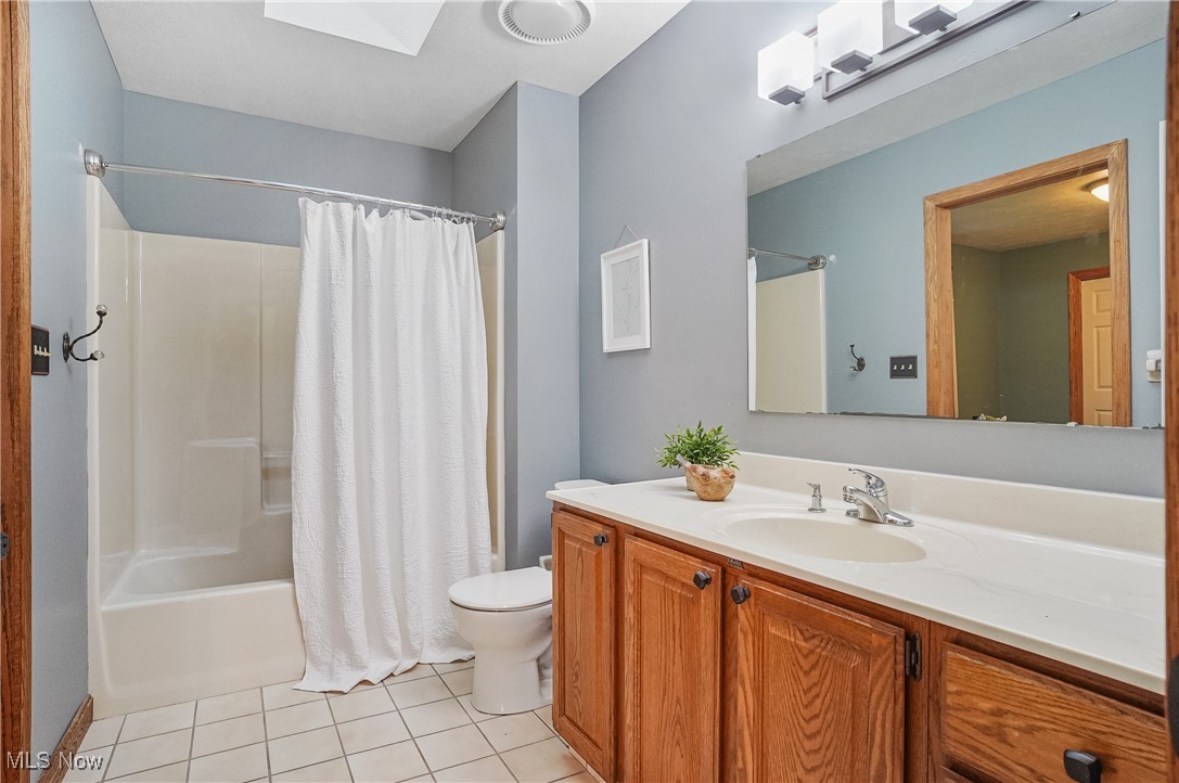 370 Wilcox Road Youngstown, OH 44515 - Photo 25 of 49 Full bath with tile patterned floors, shower / bath combo with shower curtain, vanity, and a skylight