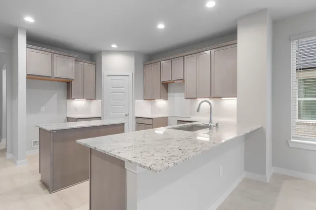 a kitchen with granite countertop white cabinets and a refrigerator
