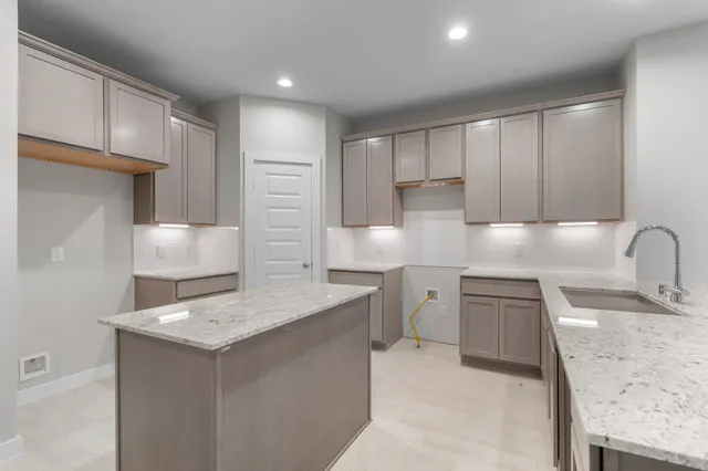 a kitchen with a sink refrigerator and cabinets