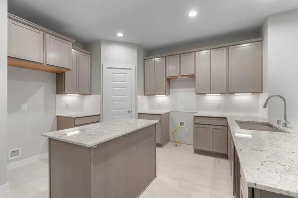 a kitchen with a sink refrigerator and cabinets