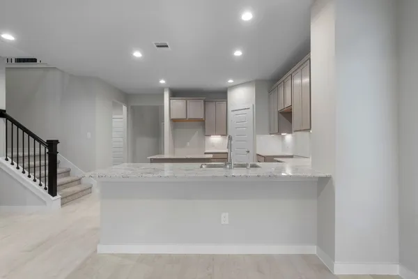 a view of a kitchen with kitchen island a sink stainless steel appliances and cabinets