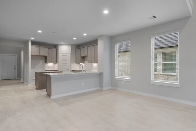 a large kitchen with kitchen island a sink stainless steel appliances and cabinets