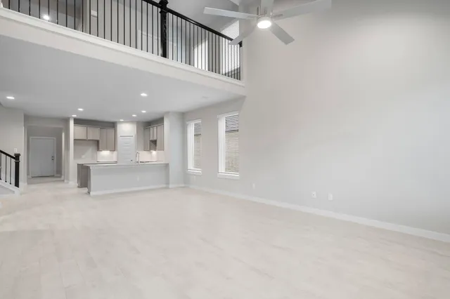 a view of a kitchen with white cabinets and wooden floor