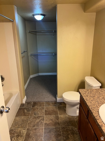 917 South Main Street, Unit H Layton, UT 84041 - Photo 11 of 19 Bathroom featuring vanity, a walk in closet, a textured ceiling, and shower / bathtub combination
