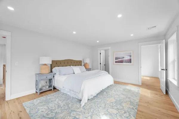 a spacious bedroom with a bed and a painting