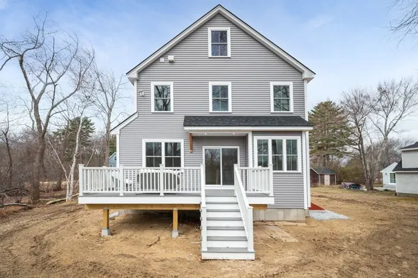 a view of a house with a yard and wooden fence