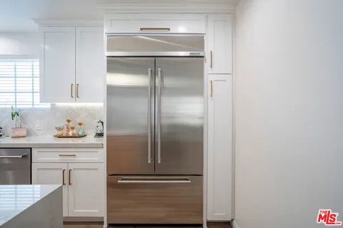 a large white kitchen with a stove and a refrigerator