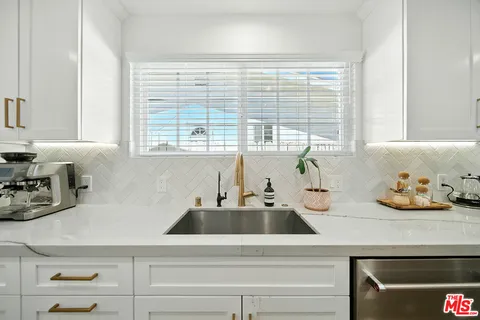 a kitchen with a sink and chairs
