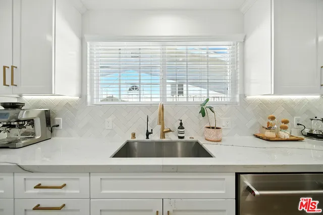 a kitchen with a sink and chairs