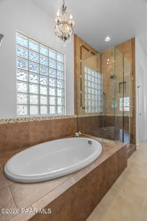 a spacious bathroom with a bathtub and chandelier