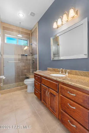 a bathroom with a granite countertop sink a toilet and bathtub