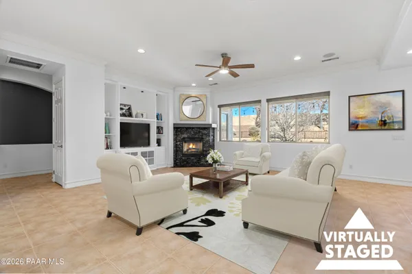 a living room with furniture a flat screen tv and a fireplace