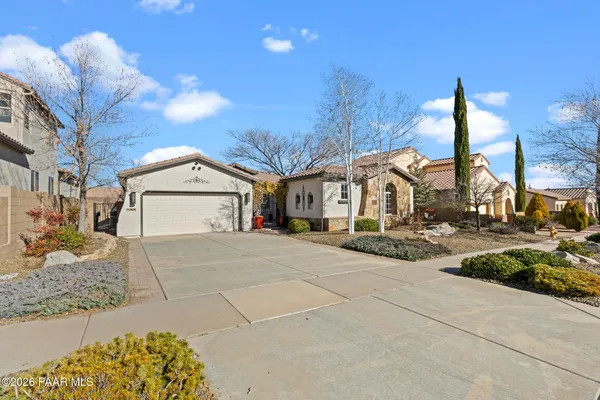 a view of a house with cars park next to a road