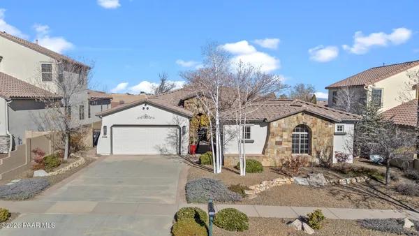 a view of a white house with a yard and large tree