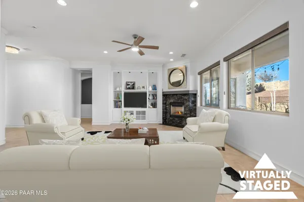 a living room with furniture a large window and a fireplace