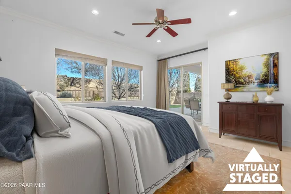 a bedroom with a large bed and a flat tv screen on dresser