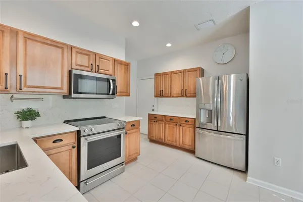 a kitchen with stainless steel appliances granite countertop a refrigerator stove and sink