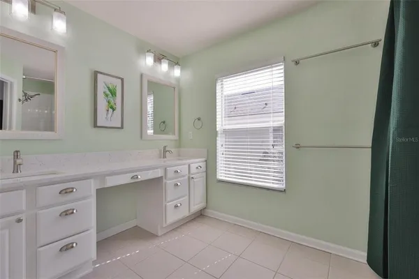 a bathroom with a granite countertop sink mirror and a bathtub