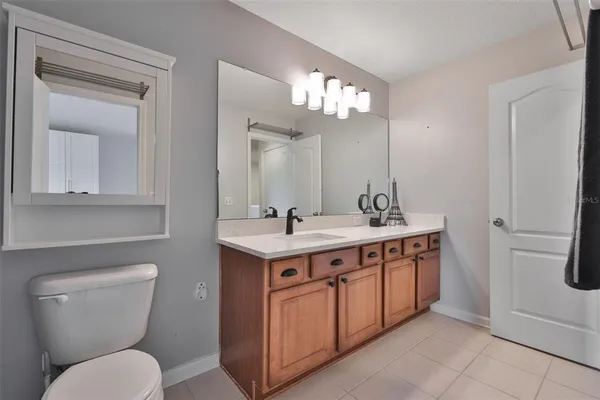 a spacious bathroom with a toilet a sink a mirror and vanity