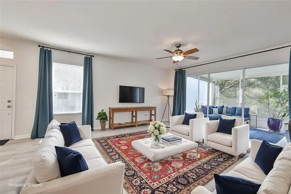 a living room with furniture a large window and a flat screen tv