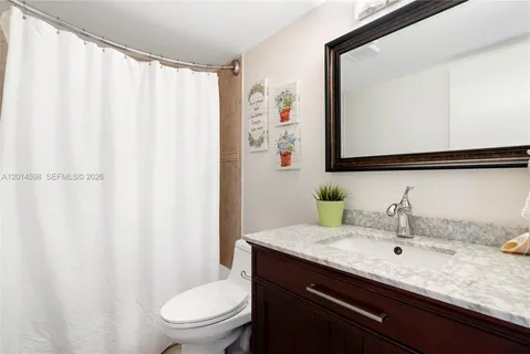 a bathroom with a granite countertop sink and a mirror
