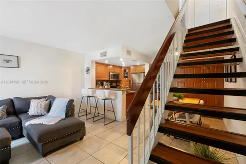 a view of staircase with lots of frames on wall and a potted plant