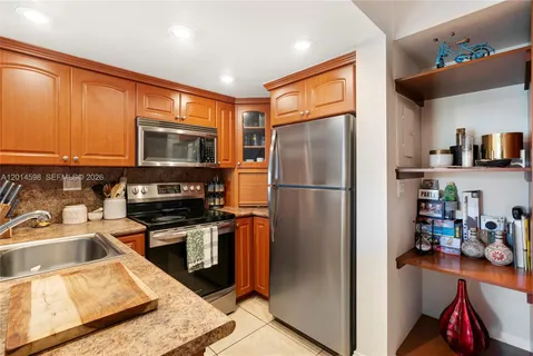 a kitchen with stainless steel appliances granite countertop a refrigerator stove and sink