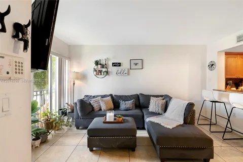 a living room with furniture and a potted plant next to a window