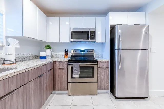 a kitchen with a refrigerator and a stove top oven