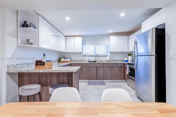 a kitchen with a sink a refrigerator and wooden cabinets