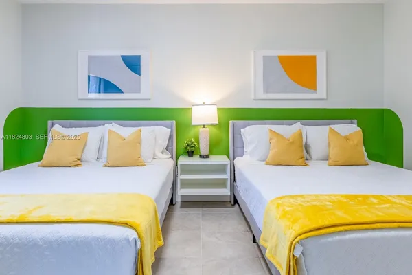a bedroom with a bed and painting on the wall