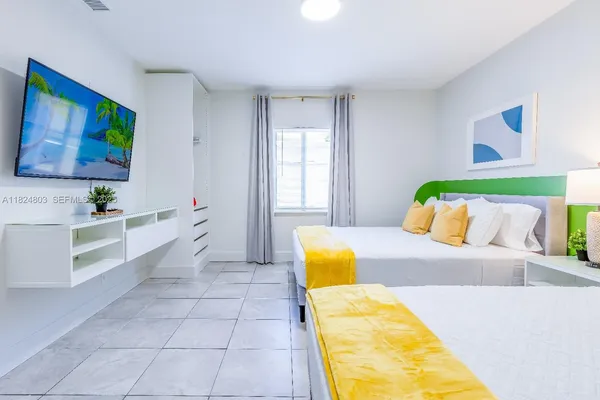 a bedroom with a bed and a flat screen tv