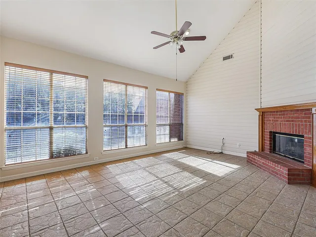 a view of an empty room with a fireplace and a window