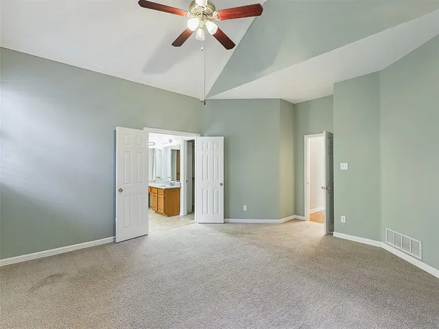an empty room with fan and windows