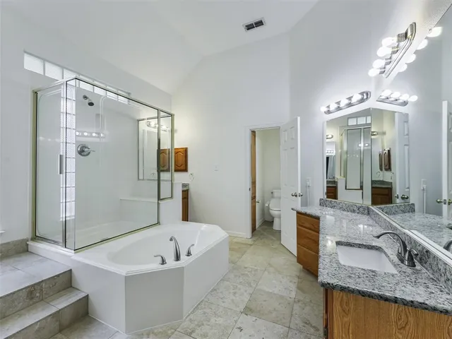 a bathroom with a granite countertop tub sink and mirror