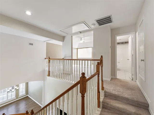 a view of a hallway with windows and stairs