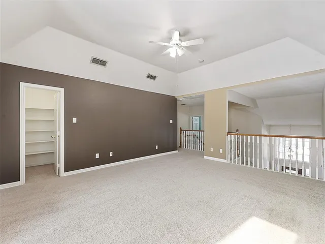 a view of an empty room with a ceiling fan