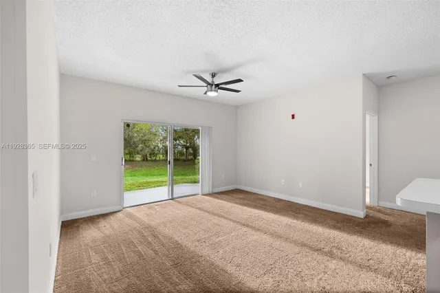 a view of a room with a ceiling fan and a window
