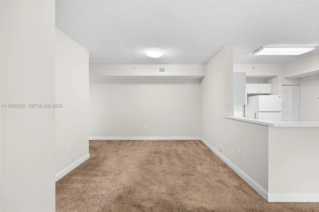 a kitchen with a sink a refrigerator and cabinets