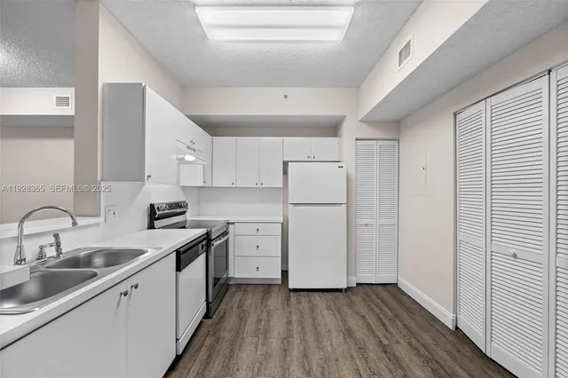 a kitchen with cabinets appliances and a sink