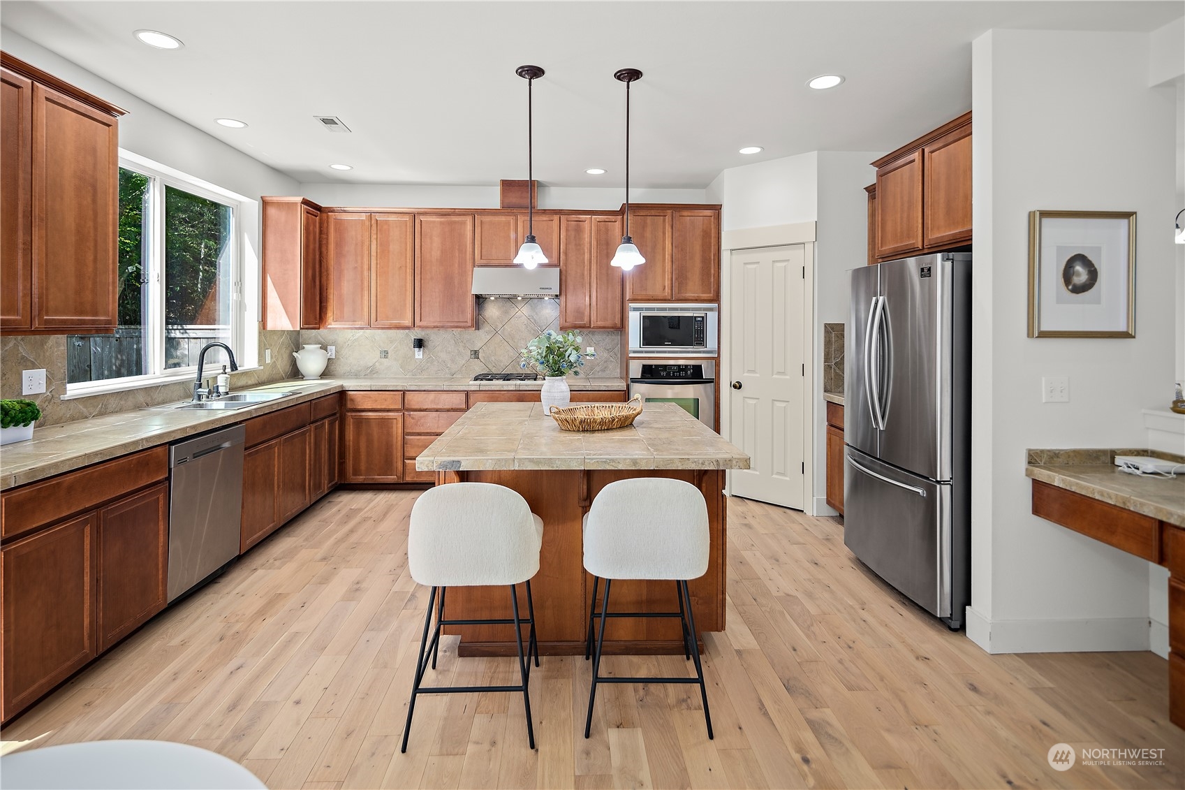 22920 36th Avenue Southeast Bothell, WA 98021 - Photo 12 of 30 a kitchen with stainless steel appliances granite countertop a refrigerator a sink a stove a dining table and chairs