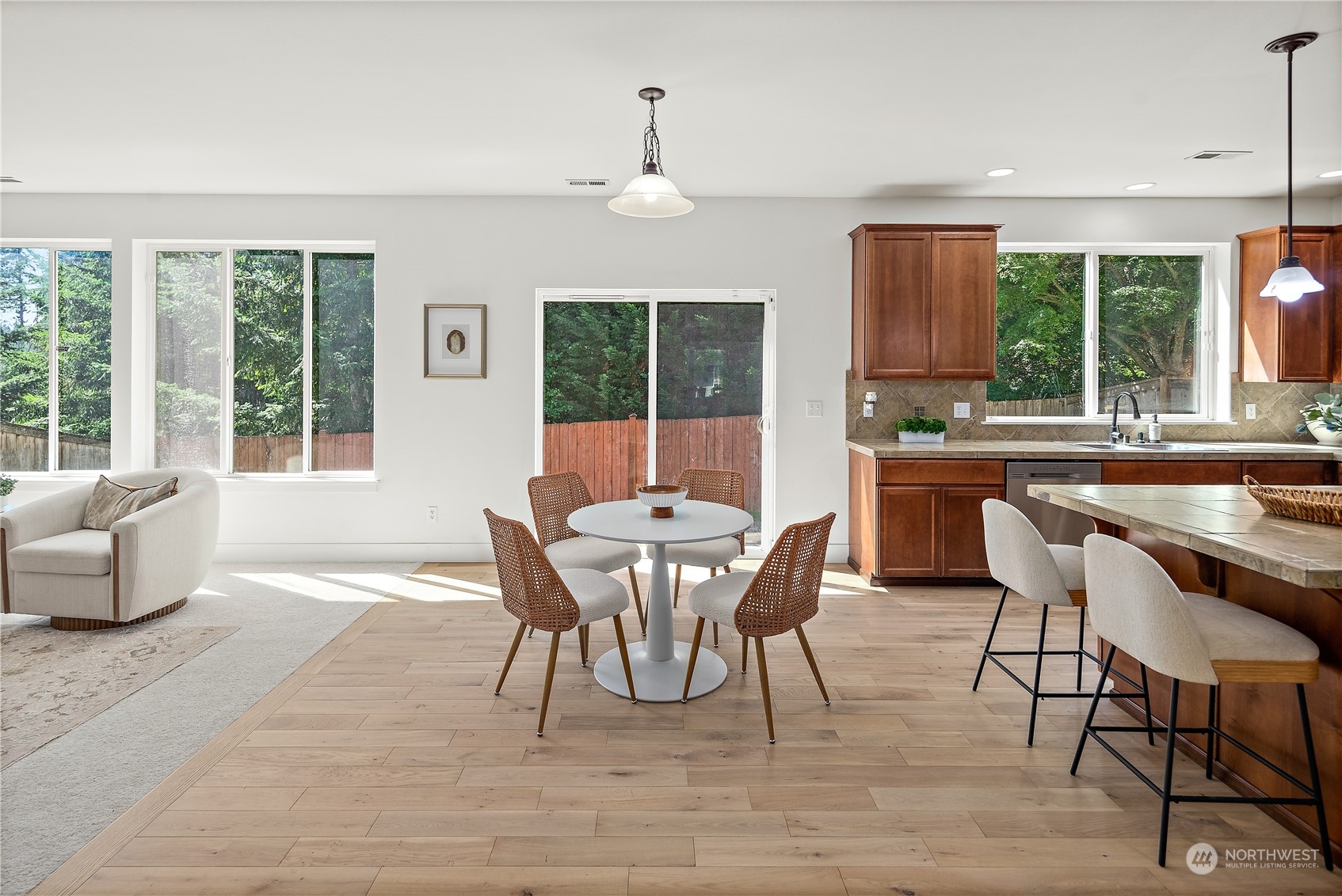 22920 36th Avenue Southeast Bothell, WA 98021 - Photo 7 of 30 a dining room with wooden floor a chandelier a glass table and chairs