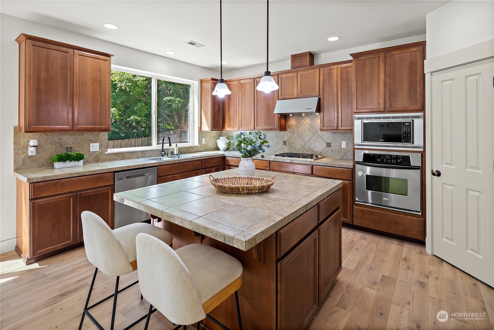 22920 36th Avenue Southeast Bothell, WA 98021 - Photo 10 of 30 a kitchen with stainless steel appliances granite countertop a kitchen island a stove a table and chairs in it